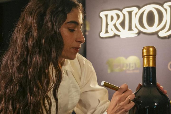 Carolina Yuste, firmando una botella de vino Rioja tras los Goya.