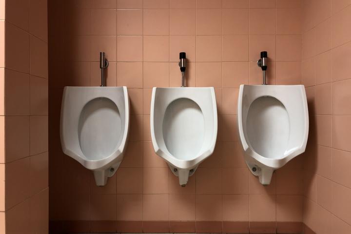 Tres urinarios en un baño público.