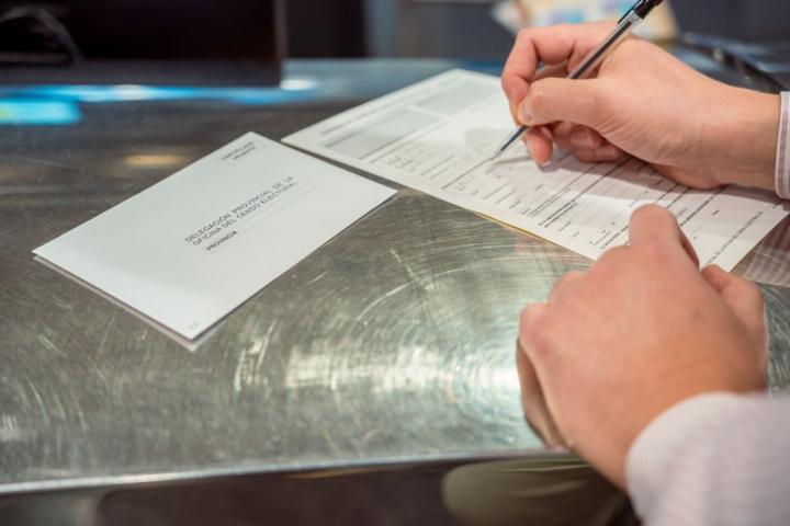 Una persona rellena un formulario para votar por Correo el 14 de junio de 2023.