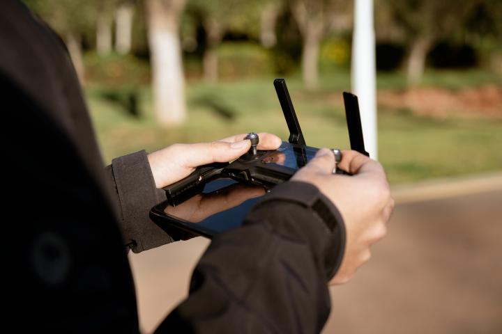 Una persona controlando un dron mediante un joystick.