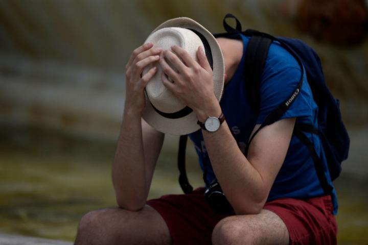 Un hombre se protege como puede en un día de calor fuerte en Sevilla