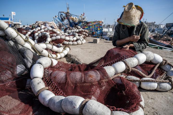 Un pescador cose las redes en el puerto de Essaouira, Marruecos.