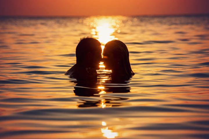 Una pareja besándose en el mar.
