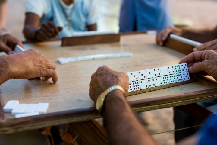 Jugadores de dominó echan una partida en la mesa de un bar.