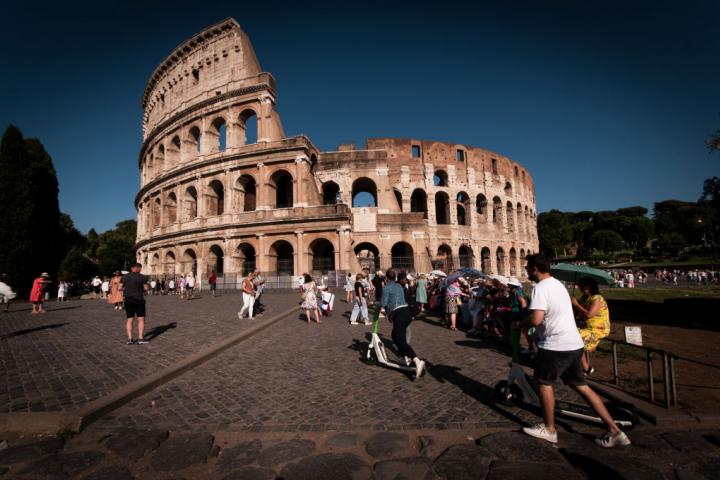 Turistas pasan por delante el Coliseo de Roma.