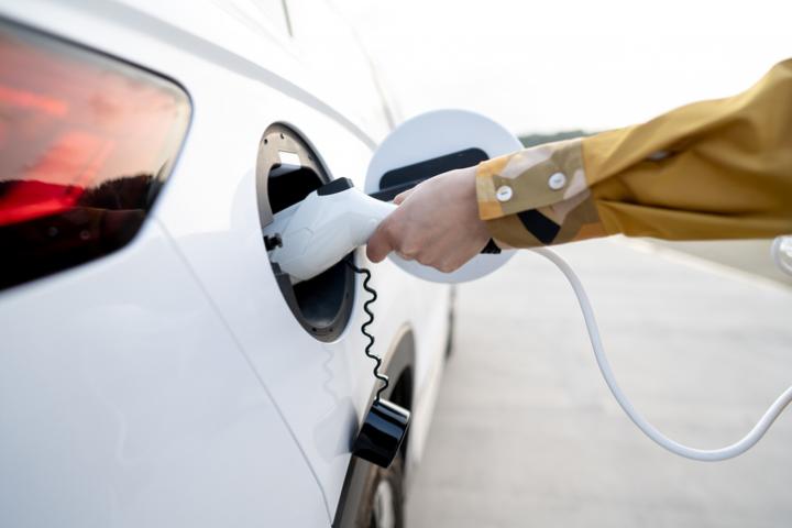 Una persona carga un coche eléctrico.