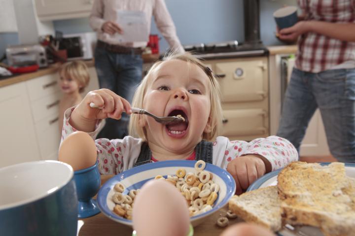 Una niña desayunando.