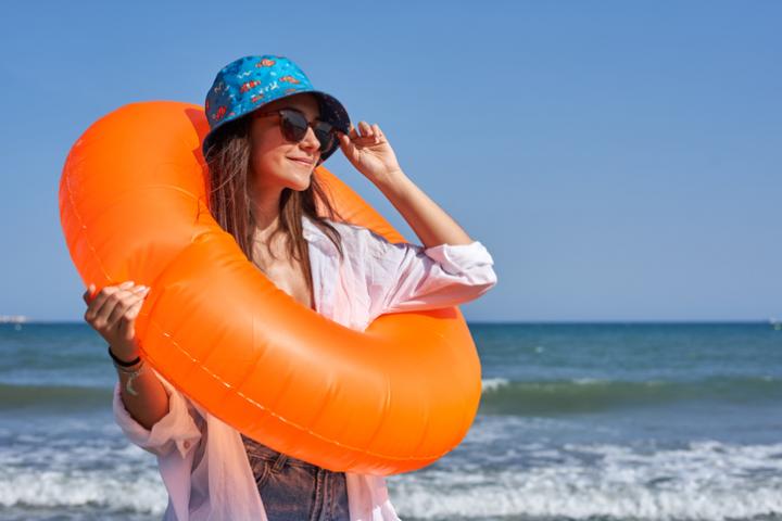 Una chica se coloca las gafas de sol junto al mar en una imagen de archivo.