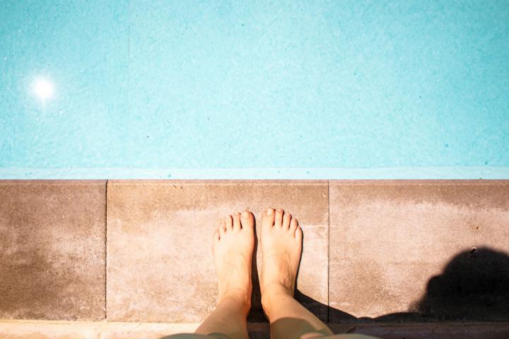 Imagen de archivo de una persona ante una piscina.