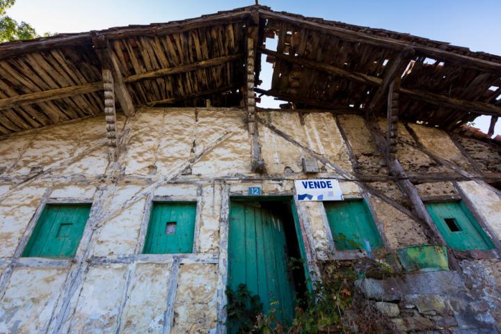 Vivienda abandonada en el País Vasco con el cartel de 'Se Vende' en su fachada.