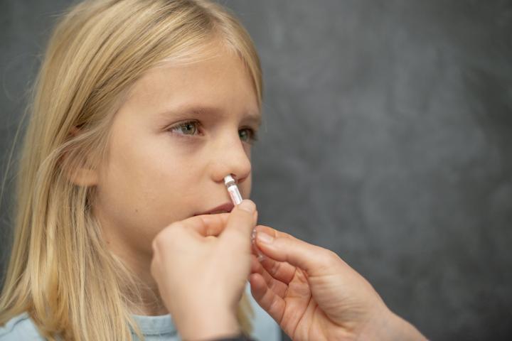 Un menor recibiendo una vacuna intranasal.