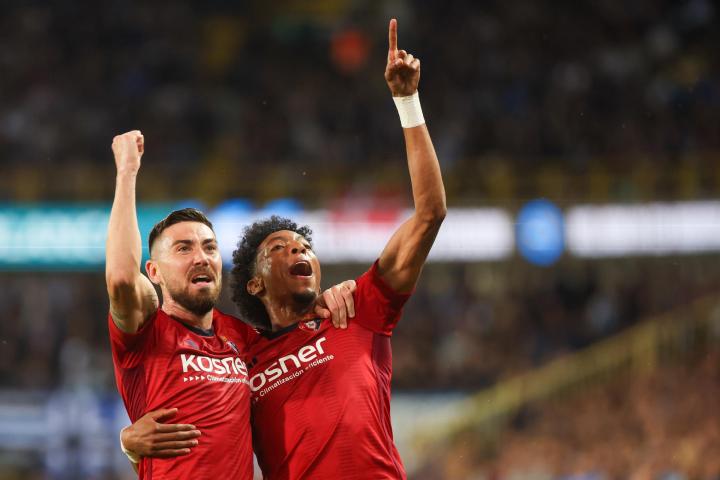 Moi Gomez y Johan Mojica celebran uno de los goles anotados ante el Brujas en Conference League.