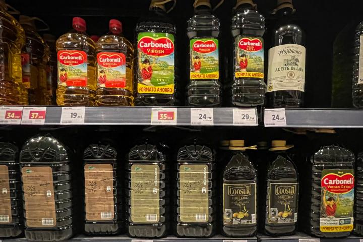 Imagen de archivo de botellas de aceite de oliva en el estante de un supermercado.