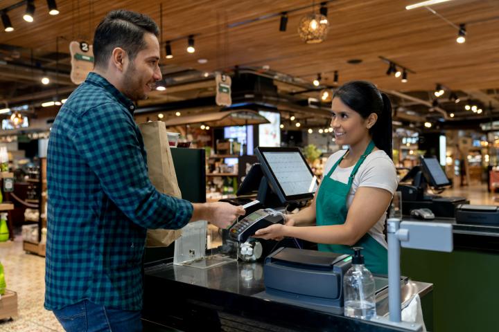 Imagen de archivo de un hombre pagando la compra en la caja de supermercado.
