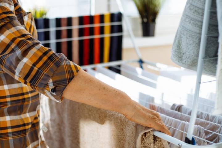 Una persona tendiendo su ropa en un tendedero