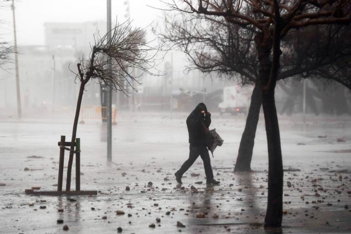 Un hombre camina en medio de un temporal en Barcelona