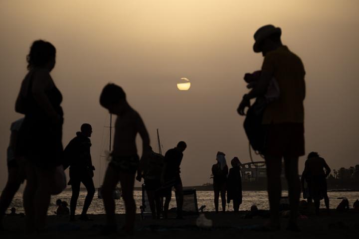 Personas quedándose hasta la puesta de sol en las playa de Las Vistas en Santa Cruz de Tenerife, ante el elevado calor.
