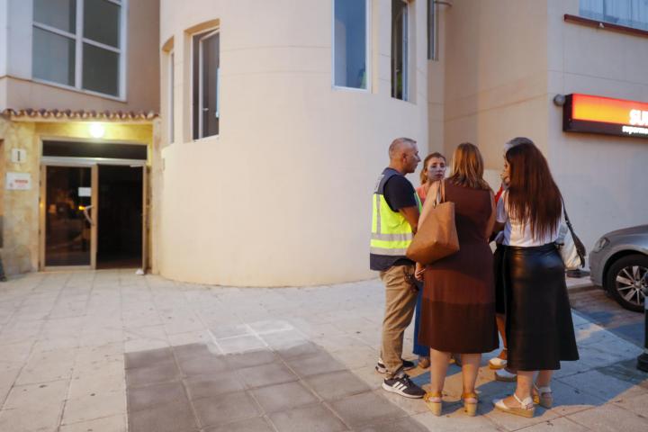 La policía Científica habla con concejales de Málaga en a la entrada del edificio donde han aparecido los cadáveres.