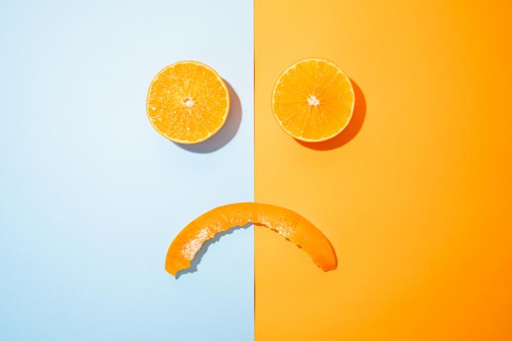 Imagen de archivo de gajos de naranja dibujando un rostro triste.