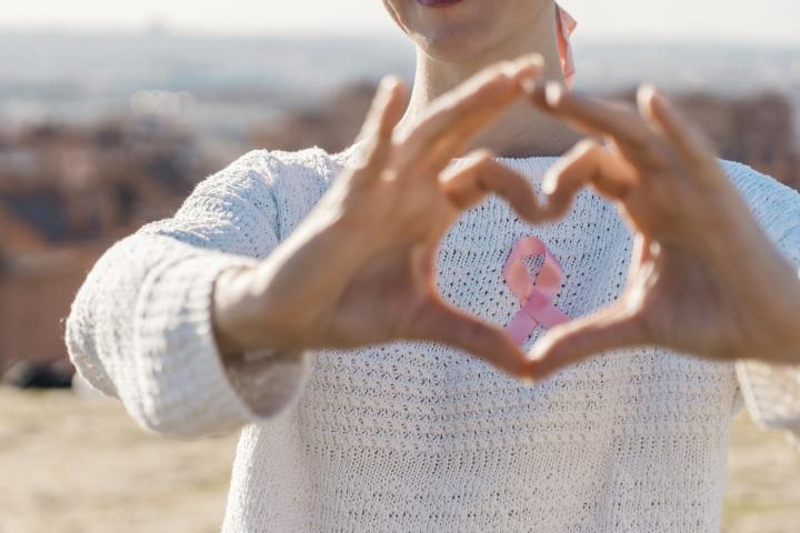 Una mujer con el icónico lazo rosa contra el cáncer de mama.