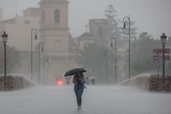 Una persona pasea bajo una tromba en Valencia