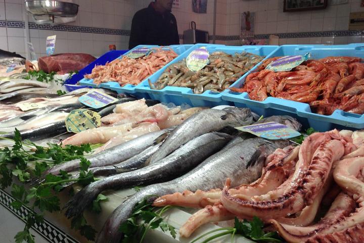 Un pescadero ofrece marisco y pescado.