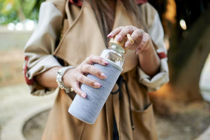 Una mujer sostiene una botella de cristal.