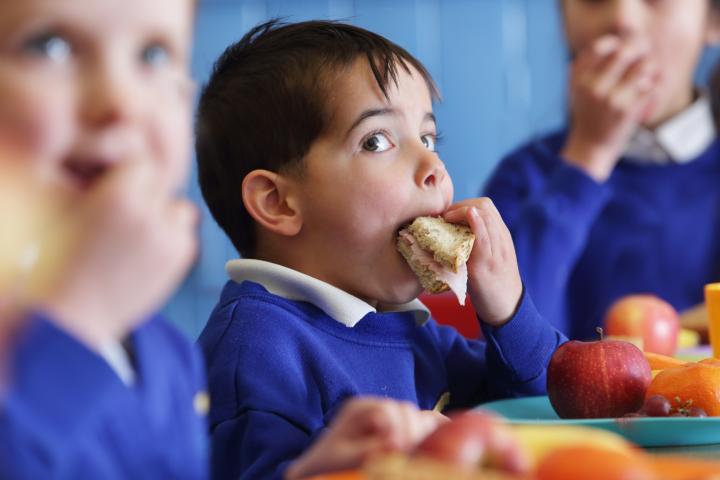 Imagen de archivo de un niño comiendo en el colegio.