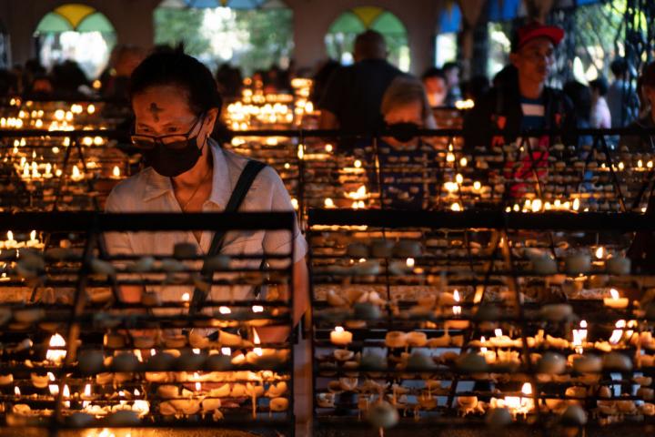 Una devota católica pone una vela en una iglesia en Manila.