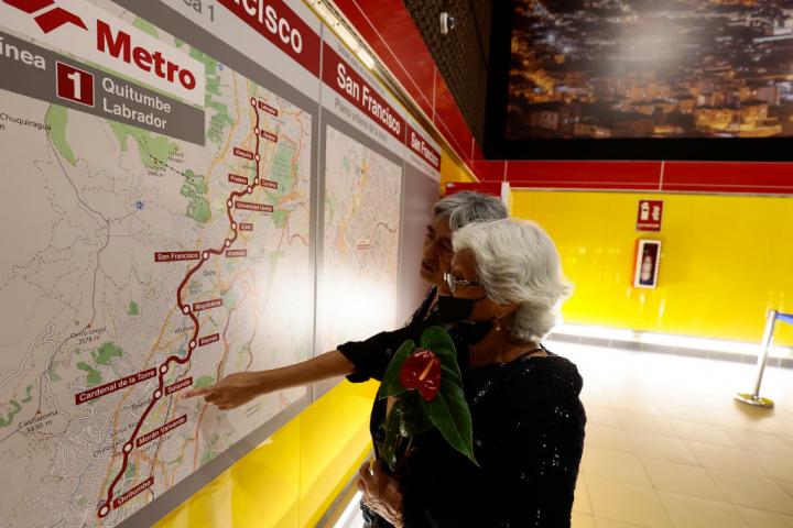 Dos ciudadanas señalan el mapa de las paradas de la única línea del Metro de Quito.