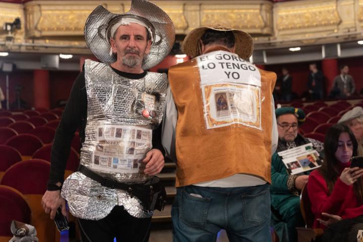 Dos asistentes al Sorteo de la Lotería de Navidad de 2022 en el Teatro Real vestidos como Don Quijote y Sancho Panza.