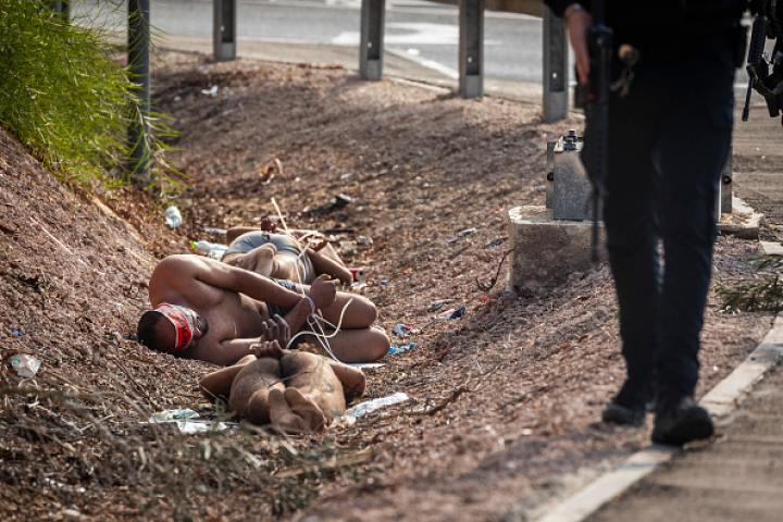 Varios palestinos bajo custodia policial israelí, tras ser desnudados en medio de la vía pública.