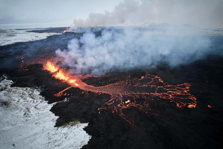Fotografía aérea tomada con un drone muestra lava y humo saliendo de una fisura volcánica durante una erupción cerca de la ciudad de Grindavik, en la península de Reykjanes (Islandia). La Oficina Meteorológica de Islandia (OMI) anunció el inicio de una erupción volcánica fisural cerca del cráter de Sundhnuka, al noreste de Grindavik, en la noche del 18 de diciembre, tras semanas de intensa actividad sísmica en la zona. La potencia y la actividad sísmica de la erupción han disminuido con el tiempo, informó la OMI el 19 de diciembre, añadiendo que se han registrado unos 320 seísmos desde el inicio de la erupción.