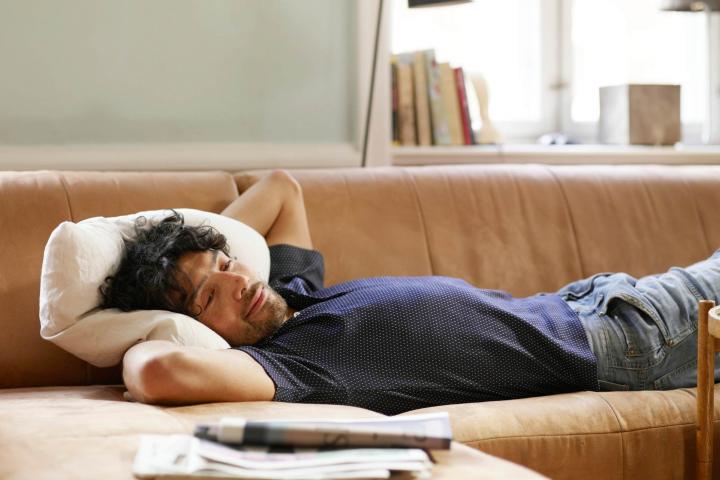 Hombre remoloneando en el sofá