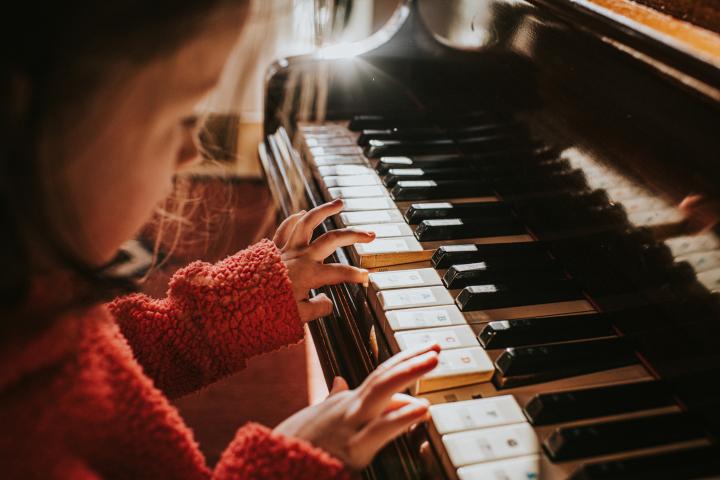 Imagen de archivo de una niña tocando el piano.
