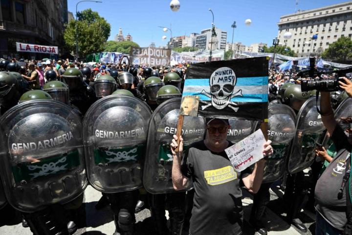 Un manifestante posa con su cartel delante del dispositivo policial este miércoles en Buenos Aires