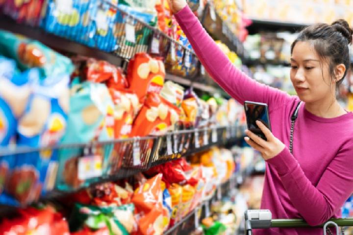Una mujer seleccionado un snack en un supermercado.