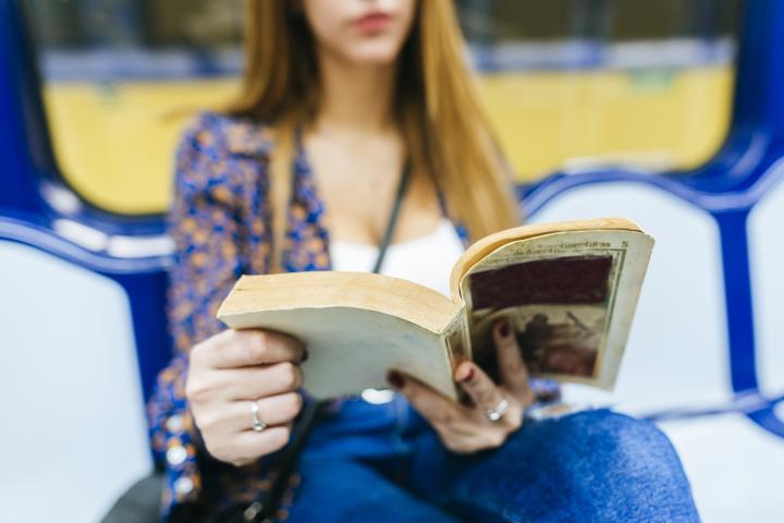 Una mujer leyendo en el metro.