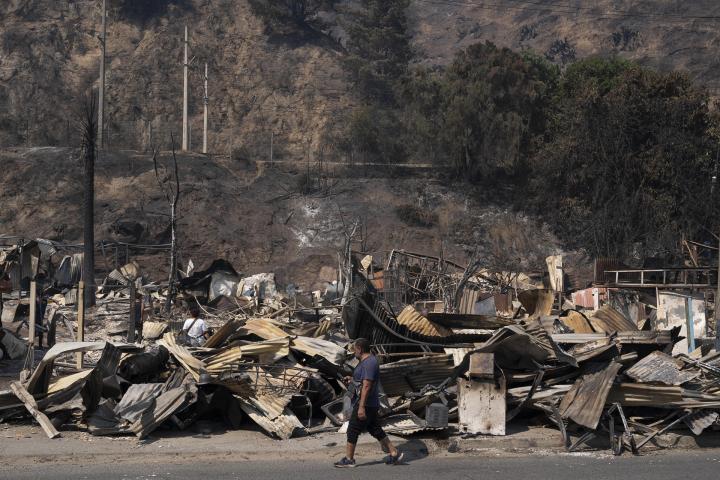 Un vecino pasa por delante de los escombros de varias casas en Viña del Mar.