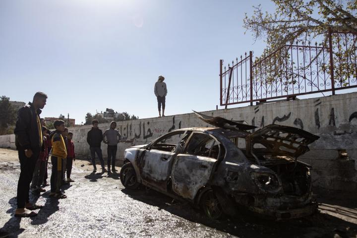 Un grupo de palestinos observa los daños causados por un ataque israelí sobre Rafah.