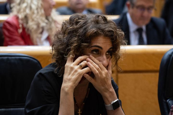 La vicepresidenta María Jesús Montero habla por teléfono en una sesión plenaria del Senado.