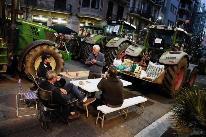 Varios de los manifestantes, acampados junto a sus tractores en pleno centro de Barcelona