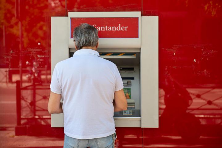 Un hombre utiliza uno de los miles de cajeros automáticos distribuidos por España.