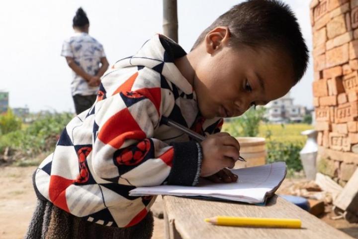 Un niño hace cuentas al lado de los ladrillos