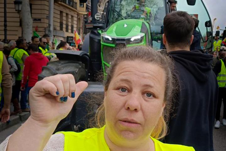 Gloria posa señalando su tractor al lado del Ministerio de Agricultura