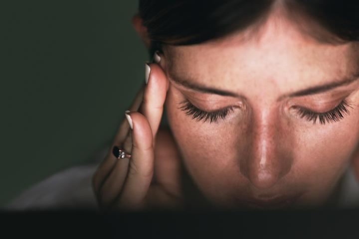 Una mujer sufriendo migraña.