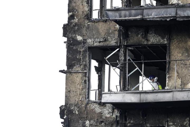 Un agente de la Policía Científica inspecciona una vivienda del edificio incendiado en el barrio de Campanar de Valencia