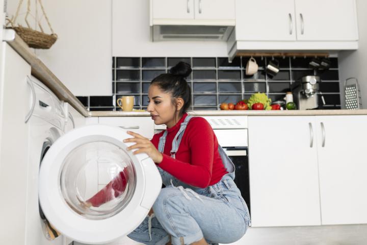 Imagen de archivo de una mujer poniendo una lavadora.