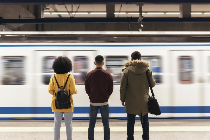 Tres personas esperando al Metro de Madrid.