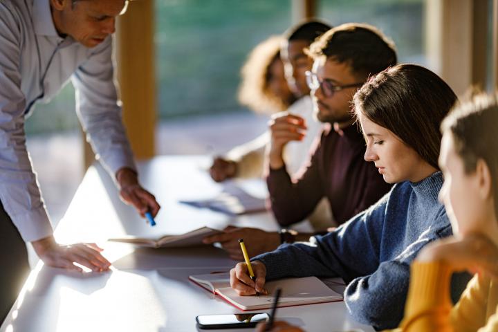 El profesor corrigiendo un ejercicio a sus alumnos.